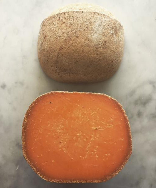 ROUND CHEESE WITH BRIGHT ORANGE INTERIOR